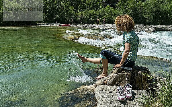 Wanderin kühlt ihre Füße in dem Fluss Isar  Bad Tölz  Bayern  Deutschland  Europa