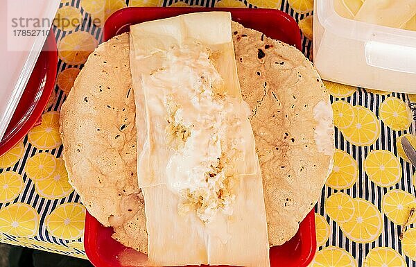 Draufsicht auf den nicaraguanischen Quesillo  der auf dem Tisch serviert wird. Traditioneller nicaraguanischer Quesillo auf einem Teller auf dem Tisch serviert. Lateinamerikanisches Essen Quesillo  Traditioneller Quesillo mit eingelegten Zwiebeln