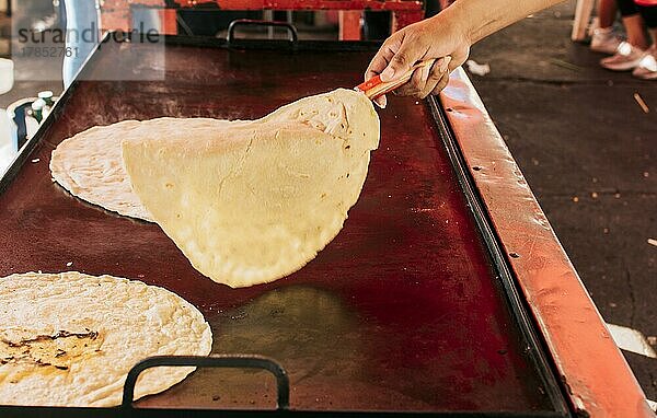 Traditionelle handgemachte Tortillas aus Nicaragua  Traditionelle handgemachte Maistortillas auf dem Grill. Hände bereiten traditionelle Tortillas auf dem Grill zu  Nahaufnahme von Händen  die Tortillas auf dem Grill wenden