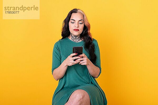 Porträt einer attraktiven Frau mit Smartphone auf gelbem Hintergrund. Kopierraum