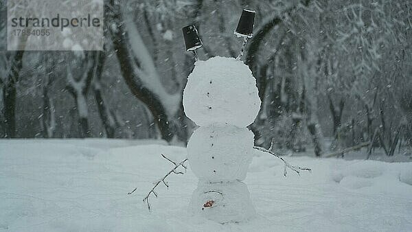 Glücklicher lustiger Schneemann-Akrobat  der auf dem Kopf steht  vor dem Hintergrund eines starken Schneefalls. Schneemann steht auf dem Kopf. Odessa  Ukraine  Europa