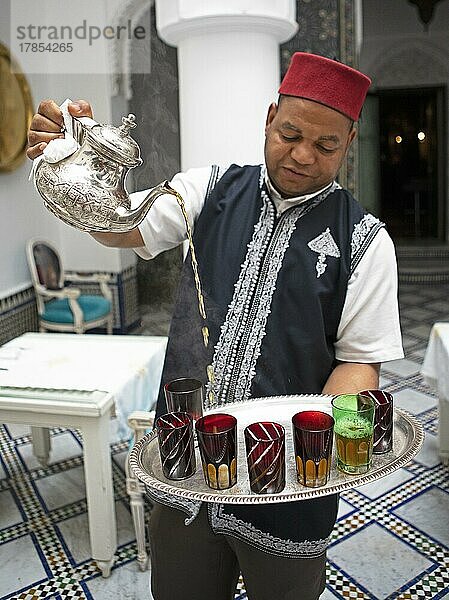 Mann gießt Tee in ein Glas  Fes  Marokko  Afrika