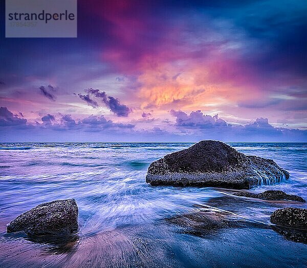 Tropischen Strand Urlaub Hintergrund  Wellen und Felsen am Strand bei Sonnenuntergang mit schönen Wolkenlandschaft