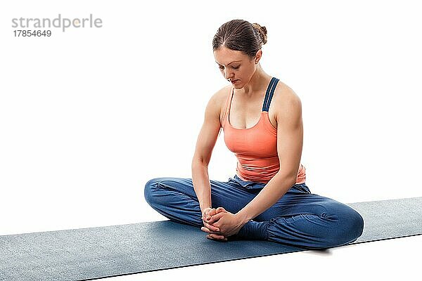 Schöne sportliche fit Frau Praktiken Yoga Asana Baddha konasana  gebundenen Winkel Pose vor weißem Hintergrund