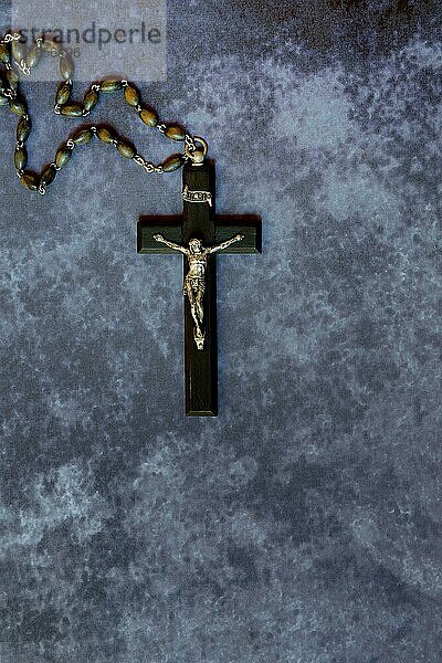 Kruzifix und Rosenkranz auf dunklem Grund