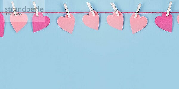 Banner mit Valentines Day rosa Papierherzen hängen von Linie mit Klammern mit leeren Kopie Raum auf blauem Hintergrund