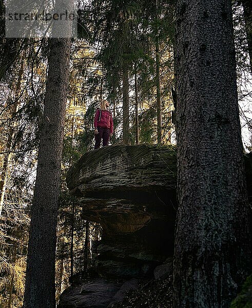 Frau in rot steht auf einem Felsen  Schwarzwald  Deutschland  Europa