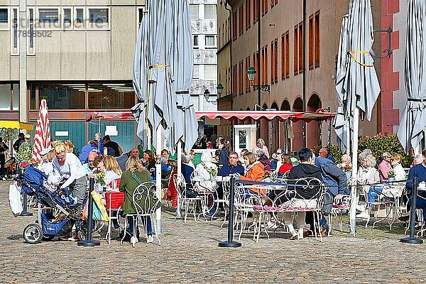 Menschen entspannen sich an einem sonnigen Tag in einem Straßencafé  Freiburg  Deutschland  Europa