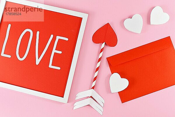 Valentinstag Zusammensetzung mit Bilderrahmen mit Text LIEBE  Amor Liebe Pfeile  roter Brief und weiße Herzen auf rosa Hintergrund