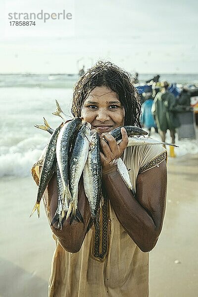 Traditioneller Fischereistrand  Plage des Pêcheurs Traditionnels  Ankunft der Fischerboote  ein Junge sammelt einzelne Fischer  die ins Wasser fallen  Nouakchott  Mauretanien  Afrika