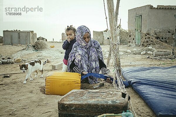 Frau füllt Trinkwasser in einen Kanister ab  Nouamghar  Mauretanien  Afrika