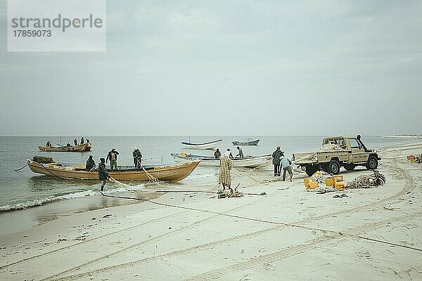 Verladen eines Netzes auf ein Fischerboot am Strand  Fischerdorf am Atlantik  Nouamghar  Mauretanien  Afrika