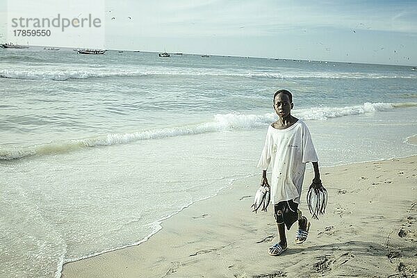 Traditioneller Fischereistrand  Plage des Pêcheurs Traditionnels  Ankunft der Fischerboote  ein Junge sammelt einzelne Fischer  die ins Wasser fallen  Nouakchott  Mauretanien  Afrika