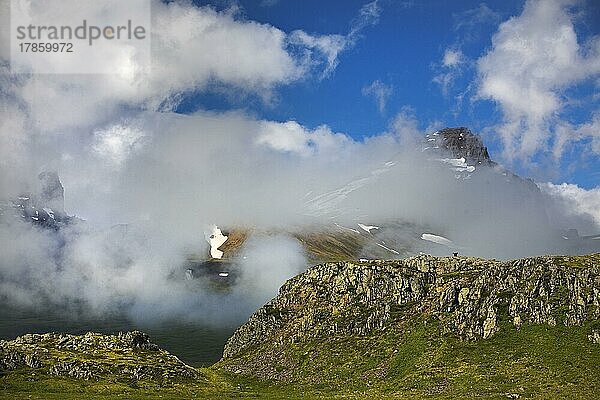 Die Alfaborg mit dem Berg Bakkafjall teilweise in den Wolken  Bakkagerdi  auch Borgarfjördur eystri genannt  Ostisland  Island  Europa