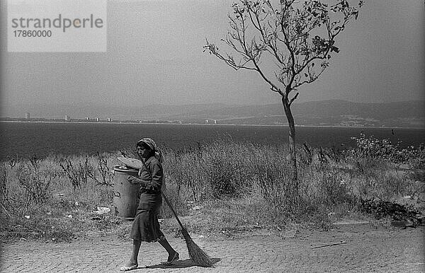 Bulgarien  Nessebar  23. 08. 1986  Frau mit Mülltonne Baum am Strand am Schwarzen Meer in Nessebar  Europa