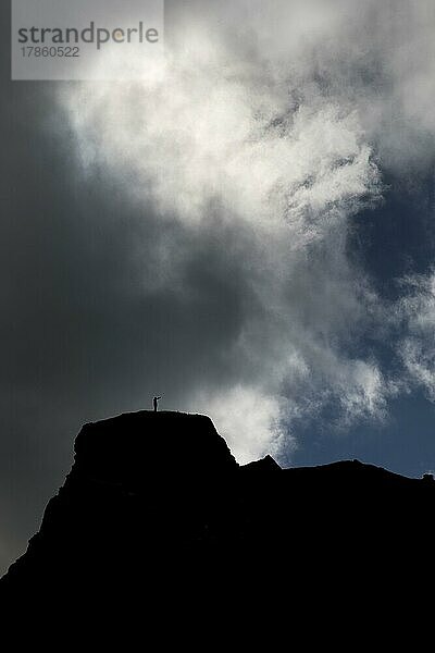 Dramatischer Himmel mit zwei Menschen vor Wolken auf einem Berg in Kirkjubæjarklaustur  Südisland  Island  Europa