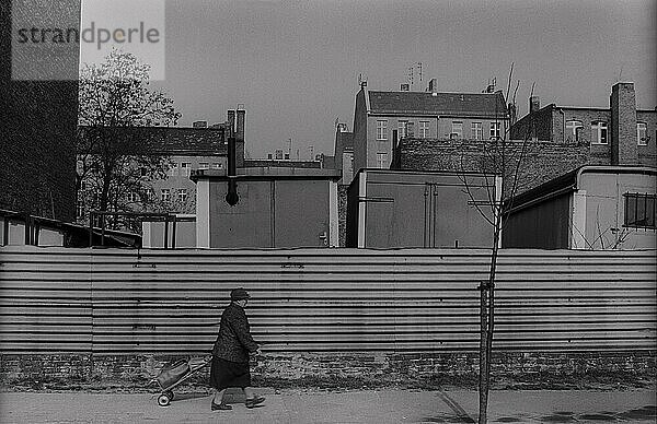 DDR  Berlin  5. 4. 1988  Bauzaun in der Choriner Straße ältere Frau mit fahrbarer Tasche
