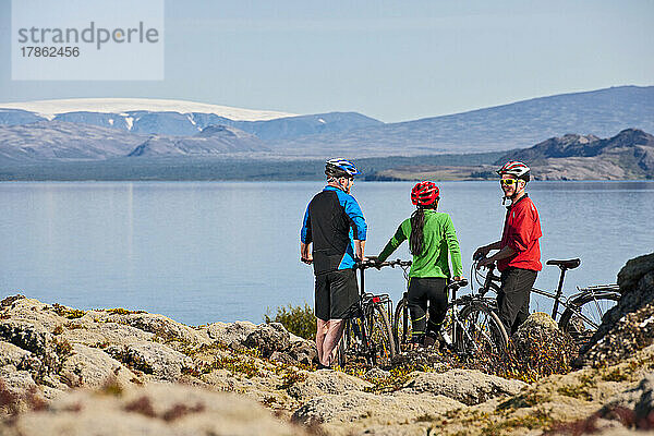 Drei Freunde radeln um den See Thinvallavatn in Island
