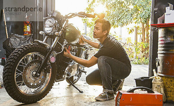 Mechaniker arbeitet am Motorrad im Custom Bike Shop in Bangkok