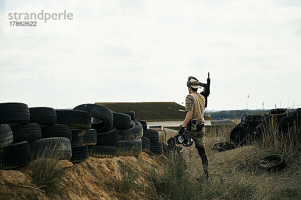 Soldat im Tarnanzug hält während eines Kampfes eine Waffe