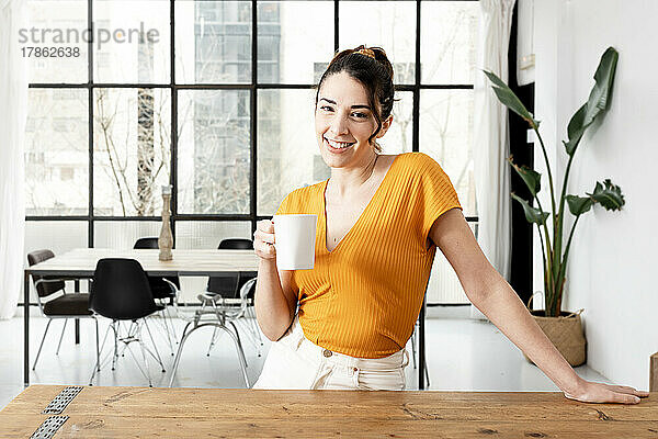 Lächelnde Frau  die früh morgens Kaffee trinkt