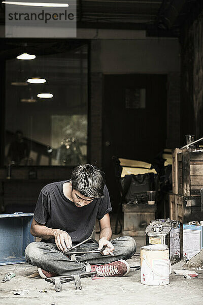 Mechaniker arbeitet an Motorradteilen im Custom-Bike-Shop in Bangkok