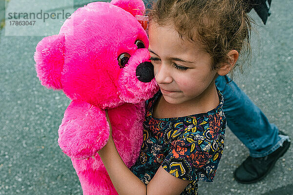 Kleines Mädchen hält rosa Stoffteddybären