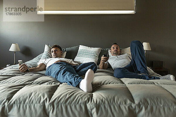 Schwules männliches Paar entspannt sich im Bett.