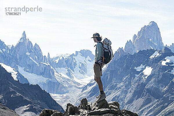 Die Silhouette eines Wanderers zeichnet sich vor den gewaltigen Gipfeln des Cerro Torre ab