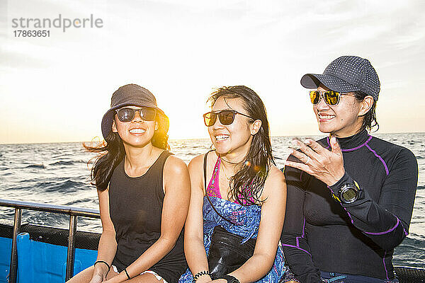 Drei Freundinnen auf einer Bootsfahrt am Tubbataha-Riff