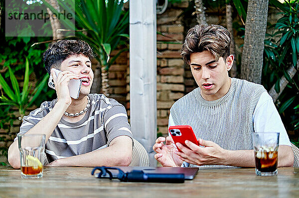 Homosexuelles Paar im Freien  das Telefon benutzt