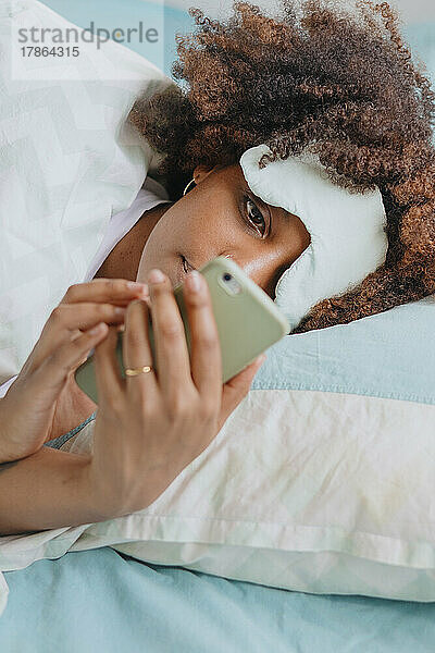 Frau im Bett mit Telefon