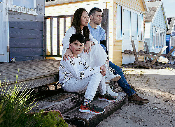 Porträt einer gemischtrassigen Familie am Strand im Sommer