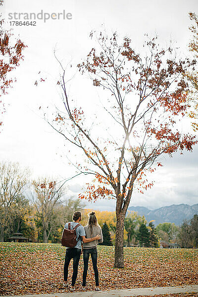 Paar hält sich an einem Herbsttag draußen  umgeben von