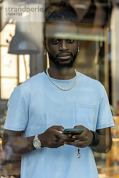 Afrikaner sendet eine Nachricht von seinem Smartphone