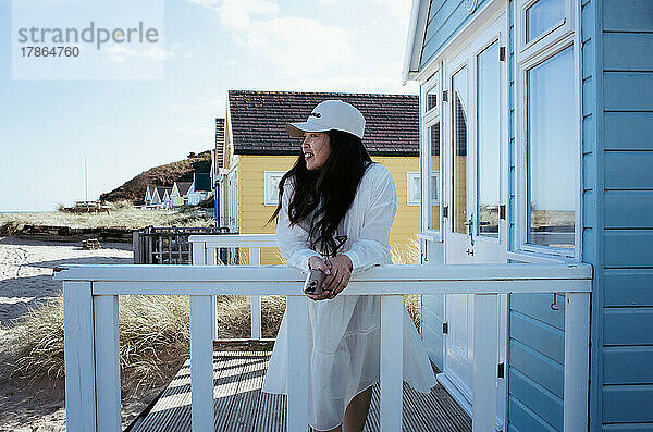 Schöne asiatische Frau stand im Sommer an einer bunten Strandhütte