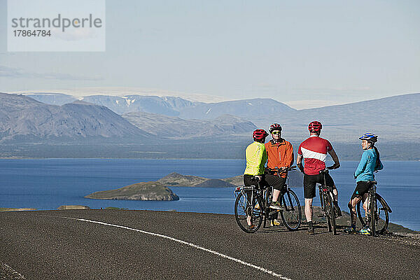 Radfahrer hält am Aussichtspunkt über dem Thingvallavatn-See