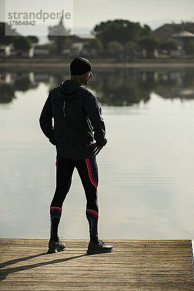 Rückansicht eines Läufers  der auf den See blickt