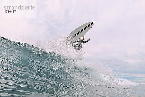 Männlicher Surfer auf einer Welle  Malediven