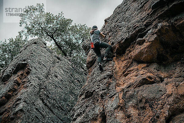 Junger Mann klettert eine Klippe im Lake Mineral Wells State Park hinauf