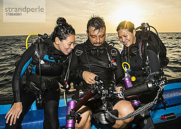 Freunde überprüfen Bilder mit einer Unterwasserkamera am Tubbataha-Riff