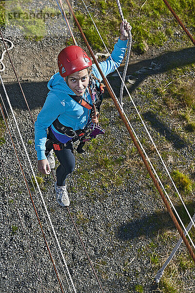 Teenager-Mädchen balanciert auf einem Seil auf einem Hochseilspielplatz in Island