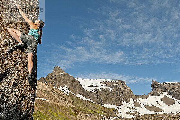 Frau beim Bouldern in den abgelegenen östlichen Fjorden Islands