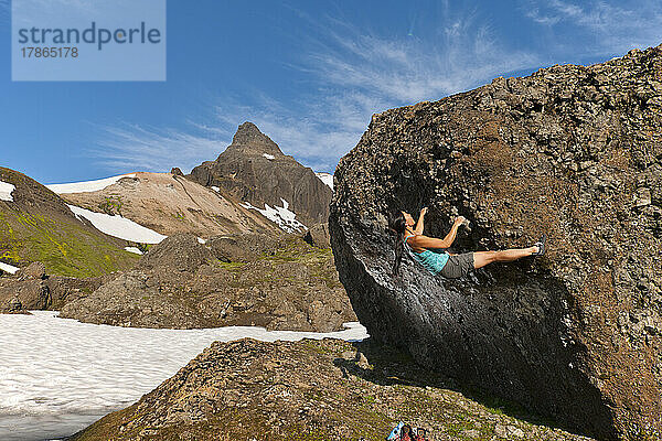 Frau beim Bouldern in den abgelegenen östlichen Fjorden Islands