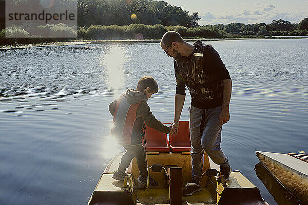 Vater und Sohn genießen Abenteuer auf dem Wasserfahrzeug-Katamaran