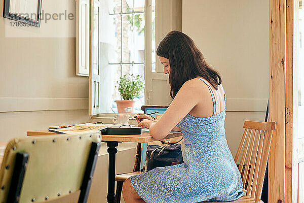 Frau zeichnet beim Frühstück in einem Café