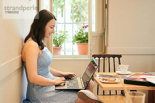 Frau arbeitet mit ihrem Laptop in einem Café