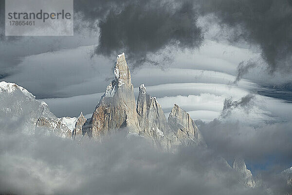 Hinter den nebligen Gipfeln des Cerro Torre bilden sich linsenförmige Wolken.