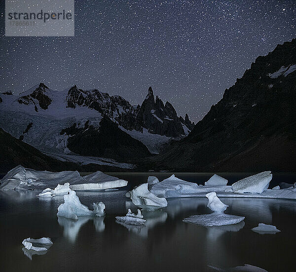 Eisberge prägen das Ufer der Laguna Torre  das nachts beleuchtet ist
