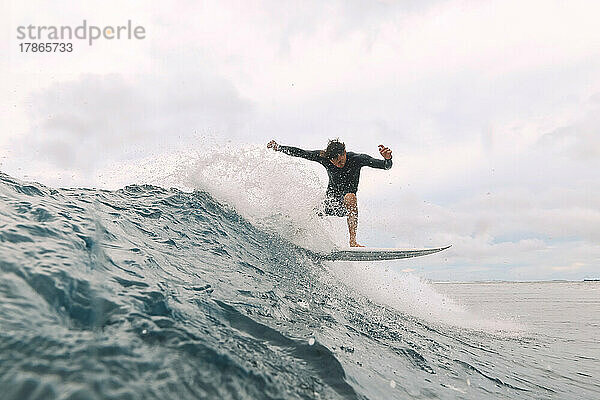 Männlicher Surfer auf einer Welle  Malediven